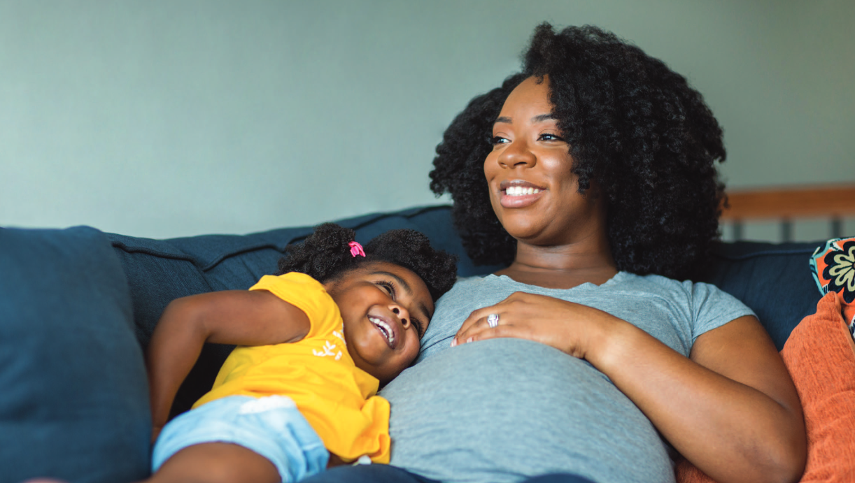 Office of African American Affairs (Involved) mother and child laying down smiling
